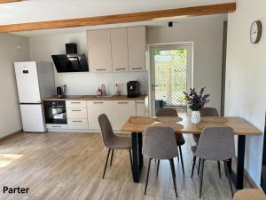 a kitchen and dining room with a table and chairs at Trzy Tarasy Swornegacie in Swornegacie
