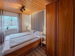 a bedroom with a large bed and a window at FeWo Friesenperle - Schillig in Horumersiel
