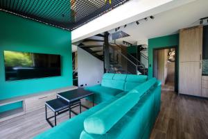 a living room with a blue couch and a tv at Prime - Event & Relax Resort in Jaszczurowa