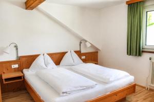 ein Schlafzimmer mit einem weißen Bett und einem grünen Fenster in der Unterkunft Appartements-Restaurant Schwaiger direkt beim Lift und wunderschönen Bergblick in Tauplitz