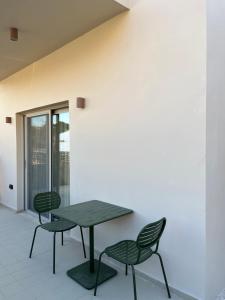a table and two chairs sitting next to a wall at MIRA MARE - Apartments 1 & 8 in Stavros