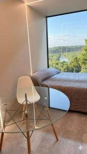 a bedroom with a glass table and a bed at Destinar Tiny House in San Pedro