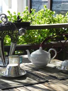 a tea pot and a faucet on a table at Les chambres du Chat Perché in Le Havre +23 photos