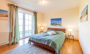 a bedroom with a bed and a large window at Schleimündeblick in Olpenitz