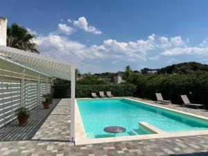 a swimming pool in a backyard with a white fence at Villa Santa Venera in Marsala