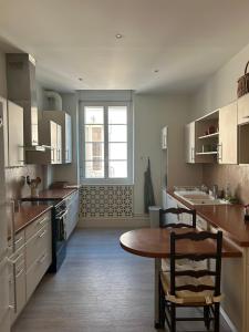 a large kitchen with a table and a window at Agen centre in Agen