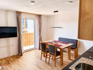 ein Esszimmer mit Tisch und Stühlen und einem Fenster in der Unterkunft Appartements-Restaurant Schwaiger direkt beim Lift und wunderschönen Bergblick in Tauplitz