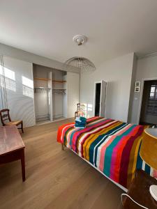 a bedroom with a bed with a colorful striped blanket at Agen centre in Agen
