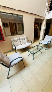 ein Wohnzimmer mit Sofas, Tisch und Stühlen in der Unterkunft Hotel NIKYASAN in Antofagasta
