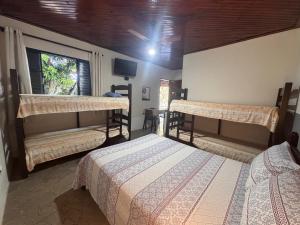 a bedroom with two bunk beds and a window at Chalés Talismã in Caconde