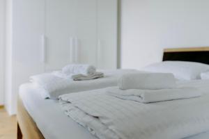 two white beds with towels on top of them at Beach SUN and FUN Penthouse in Podersdorf am See +26 photos