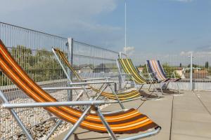 a row of lawn chairs sitting on a patio at Beach SUN and FUN Penthouse in Podersdorf am See