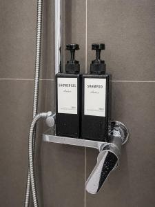 two bottles of soap and a shower head in a bathroom at Appartamento Martina in Lanusei +19 photos