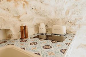 two coffee makers on a tiled counter in a bathroom at Siede la Terra - Trullo con piscina in Ceglie Messapica +51 photos