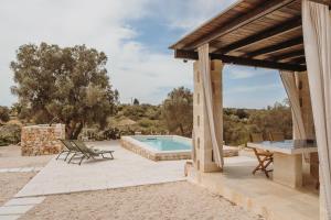 an outdoor patio with a table and a pool at Siede la Terra - Trullo con piscina in Ceglie Messapica