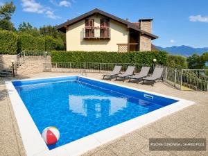 a swimming pool in front of a house at Happy Guest Apartments - Lake Panorama & Pool in Riva di Solto