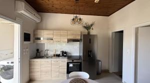 a kitchen with a refrigerator and a stove top oven at Ria's Garden House in Kassiopi