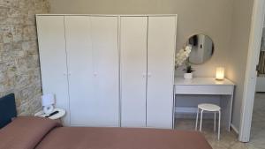 ein Schlafzimmer mit einem weißen Schrank und einem Tisch in der Unterkunft Dimora Marsè - Indipendente con area esterna privata in Moncalieri + 35 Fotos