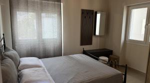a bedroom with a bed and a window at Ria's Garden House in Kassiopi +2 photos