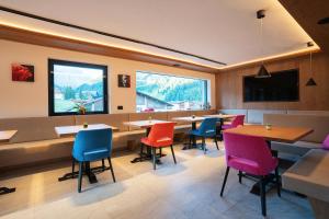 a restaurant with tables and chairs and a large window at Hotel Garni Morene in Selva di Val Gardena