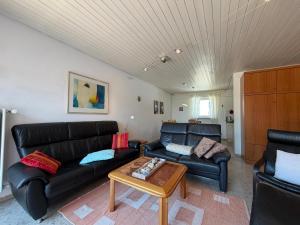 a living room with two leather couches and a coffee table at Casa Constantinus in Unteruhldingen