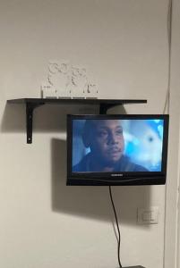 a television hanging on a wall with a shelf at Monolocale Cerreto Laghi in Cerreto Laghi