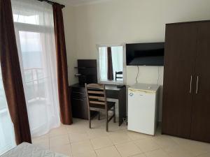 a room with a desk and a chair and a refrigerator at Вила Арапя in Tsarevo