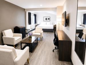 a hotel room with a bed and a living room at Quality Inn & Suites in Gatineau