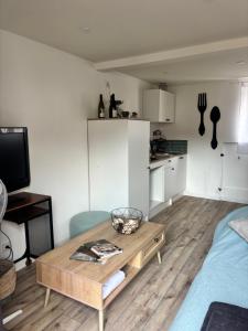 a living room with a coffee table and a kitchen at Petite halte à Volnay in Volnay
