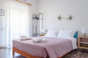 a bedroom with a large bed with two towels on it at Ostria Rooms in Palaiochora