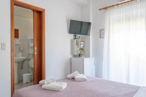 a bedroom with a bed with two towels on it at Ostria Rooms in Palaiochora