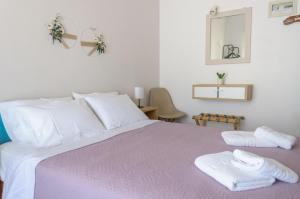 a bedroom with a bed with two towels on it at Ostria Rooms in Palaiochora +30 photos