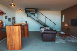 a living room with a couch and a staircase at Rancho Churrascada in Espirito Santo Do Pinhal