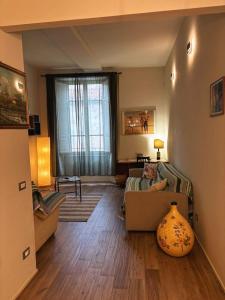 a living room with a couch and a window at Appartamento in centro storico. in Camaiore