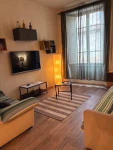 a living room with a couch and a tv at Appartamento in centro storico. in Camaiore