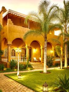 a house with palm trees in front of it at Ferme Oasis de Fes in Fez
