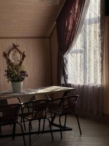 a table and chairs in a room with a window at Медовий сон in Pasichna