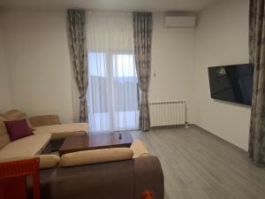 a living room with a couch and a tv at Stan Milacic in Sutomore