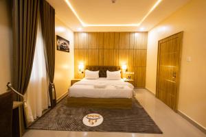 a hotel room with a bed and a door at Dodos Hotel Services in Port Harcourt