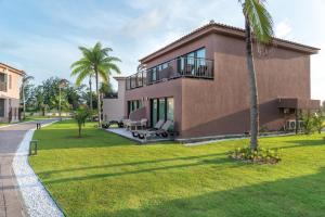 a house with a palm tree in front of it at Vila Galé Collection Sunset Cumbuco in Cumbuco