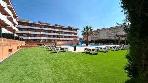a row of tables and chairs on a lawn in front of a building at Alojamientos familiares Sa Gavina Estartit, Principal in L'Estartit