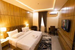 a hotel room with a bed and a television at Dodos Hotel Services in Port Harcourt