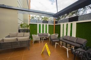 a patio with chairs and tables and a green wall at Dodos Hotel Services in Port Harcourt