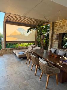 a patio with a wooden table and chairs at Gialova Hills - Luxury Villa with Private Pool, Sauna, Garden & Seaview in Gialova