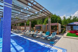 a swimming pool with lounge chairs and a pergola at Charos Family Resort in Yusufkhona
