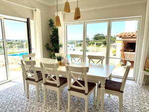 a dining room with a white table and chairs at Villa Ericeira in Ericeira +39 photos