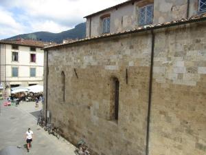 a man walking down a street next to a brick building at Appartamento in centro storico. in Camaiore