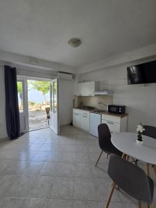 a kitchen with a table and a table and chairs at Apartmani Ante 1 in Drašnice