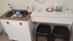 a kitchen with two black stools next to a sink at Edícula 1 em São Pedro in São Pedro