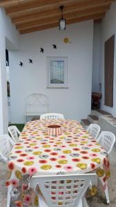 a white table with a flowery table cloth on it at Cantinho do Frangoneiro in Fortios